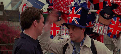 man wearing a London tourist hat that has a massive union jack on it, tilting it sassily to the side