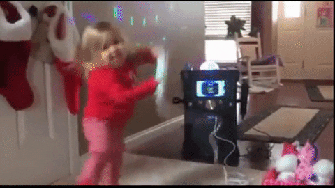 A young girl (around 4) dancing badly with the microphone of a karaoke machine. 
