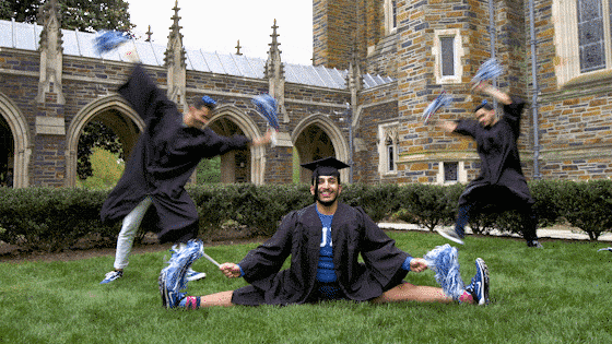 Graduates in gown and caps doing gymnastics
