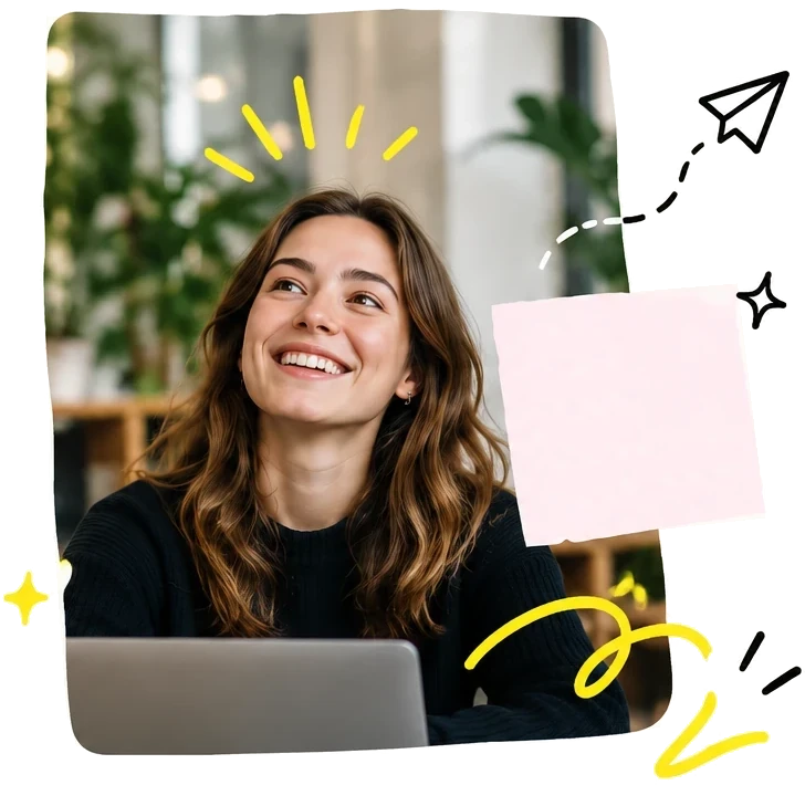 A young woman smiling at her laptop.